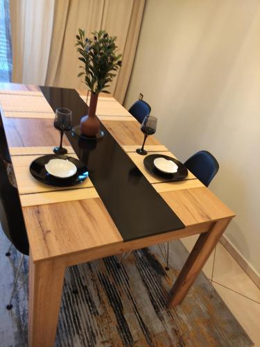 a wooden table with two plates and a plant on it at Flat30 - Cosy apartment in Park of Kipseli- Xanthi in Xanthi