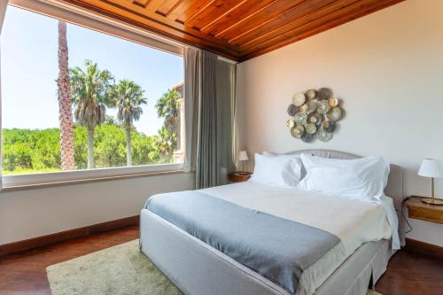 a bedroom with a bed and a large window at Casa do Marco in Sintra