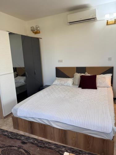 a bedroom with a large bed with white sheets at شركة دار المعرفة للعقار in Baghdād
