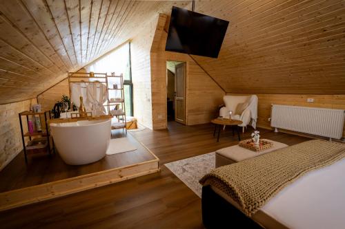 ein Schlafzimmer mit Badezimmer mit Badewanne und Bett in der Unterkunft Rose Romantic in Tărlungeni