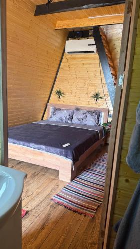 a bed in the middle of a room at Căsuța Casper in Tudora