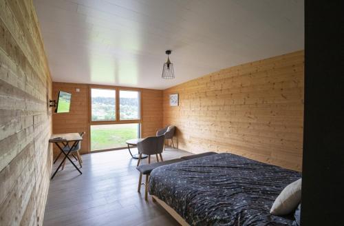 ein Schlafzimmer mit Bett, Schreibtisch und Fenster in der Unterkunft L'esca'lac in Grande Riviere