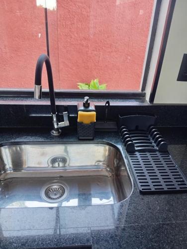 a kitchen sink with a faucet on top of it at Casa da Serra in Serra Negra