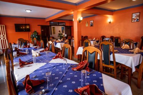 a dining room with tables and chairs with red bows at Sandton hotel kasese in Nalakonge