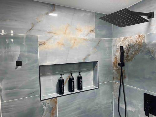 a bathroom with three black bottles on a wall at Loeras Inn in Dumfries