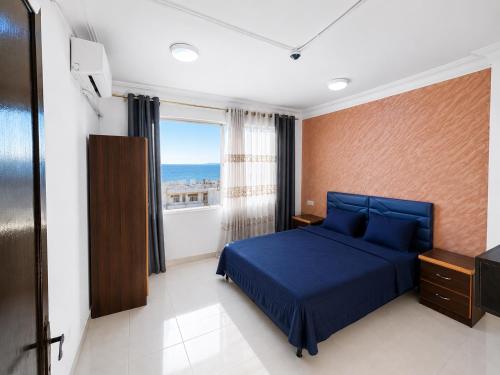 a bedroom with a blue bed and a window at Nice Apartment with Sea View in Aqaba
