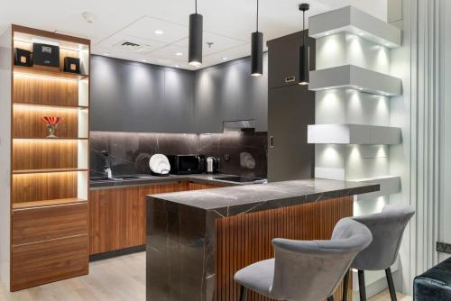 a kitchen with a counter and two stools at Yas Island Luxury Apartment by City homes in Yas Island
