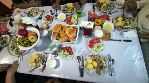 a white table with a bunch of plates of food at Akmuz House in Ak-Muz