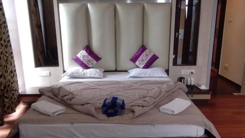 a bedroom with a large bed with purple pillows at Hotel Haven Intercontinental in Agartala
