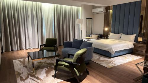 a hotel room with a bed and a couch and chairs at Paziro Hotel in Dushanbe