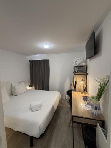 a hotel room with a bed and a table at Cit'Hôtel du Parc in Carrières-sous-Poissy