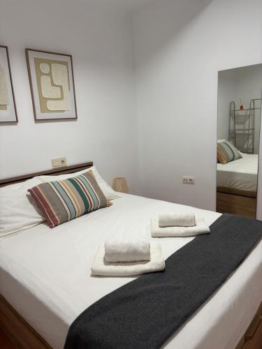 a white bed with two towels on top of it at Apartamento Salas in Ronda