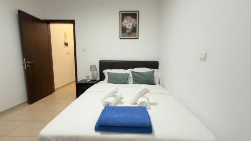 a large white bed with a blue towel on it at Arithea Hidden Seaside Heritage 2BR Suite in Paphos