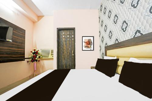 a bedroom with a large white bed and a window at Hotel O Gulabi Delight in Faridabad