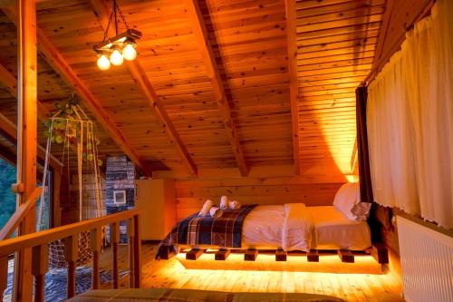 a bedroom with a bed in a wooden room at Oşvacu Dağ Evleri in Çamlıhemşin