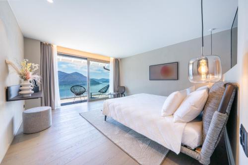 a bedroom with a bed and a large window at Exclusive Boutique Hotel Elisabetta in Ronco sopra Ascona