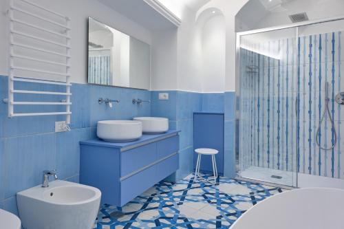 a blue and white bathroom with a toilet and a sink at Maison Blu Royal in Amalfi