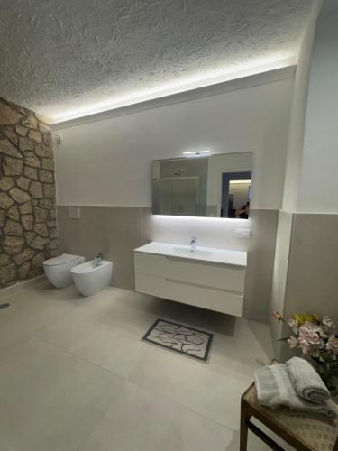 a bathroom with a sink and a toilet and a mirror at Villa Maria Marcella in Porto Santo Stefano