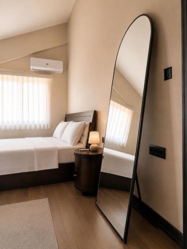 a bedroom with a bed and a mirror at Berm Suites in Antalya
