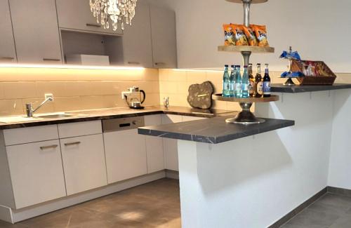 a kitchen with white cabinets and a black counter top at Haus im Herrengrund in Schollbrunn
