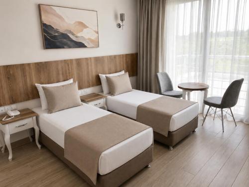 a hotel room with two beds and a table at Vel-Mer Lefke in Ayios Nikolaos