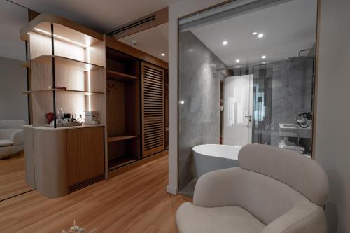 a bathroom with a tub and a chair in it at Flower Hotels & Resorts in Golem