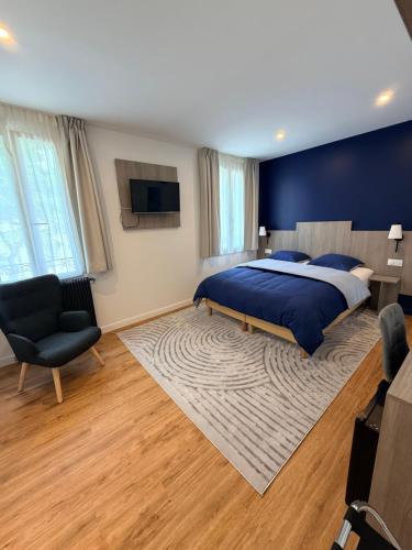 a bedroom with a large bed and a chair at Laulique in Les Lilas