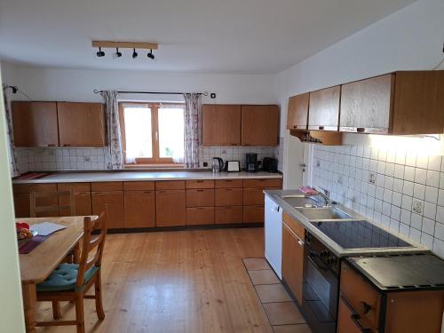 a kitchen with wooden cabinets and a table and a window at Ferienhaus Anni in Warngau