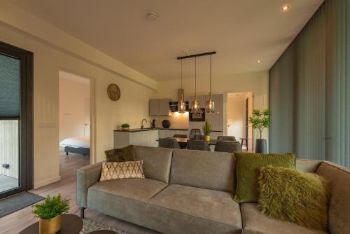 a living room with a couch and a dining room at Forest Lodge 6 persons #624 in Maasbree