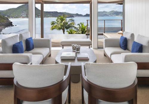a living room with couches and a table and chairs at Hotel Christopher Saint Barth in Pointe Milou