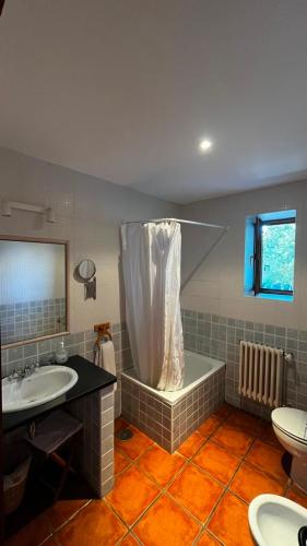 a bathroom with a tub and a sink and a toilet at Hotel Rural El Rincón de Trefacio in Trefacio
