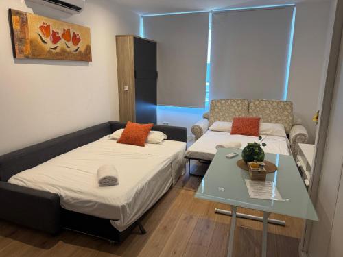 a small room with two beds and a table at A&R Isla de la Palma in San Sebastián de los Reyes