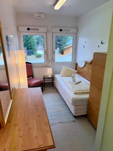 a small room with a bed and a chair and two windows at Weaky what you want in Ugine