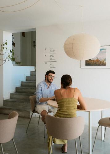 a man and a woman sitting at a table at Outsite Ericeira - Boavista in Ericeira