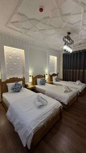 a room with three beds in a room at Amina Hotel PREMIUM in Bukhara