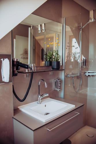 a bathroom with a sink and a mirror at Pension Sommer in Waldsassen