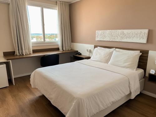 a bedroom with a white bed and a window at Swan Rio Grande in Rio Grande
