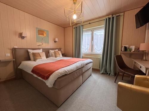 a bedroom with a bed and a desk and a window at Hôtel SPA Au Cheval Blanc - Chambres climatisées in Ribeauvillé