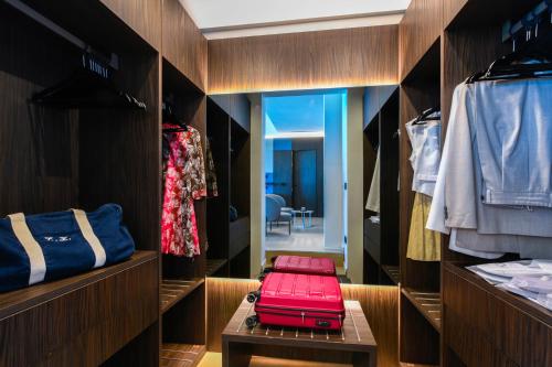 ein begehbarer Kleiderschrank mit einem roten Koffer auf einem Tisch in der Unterkunft Hotel Oliveto in Desenzano del Garda