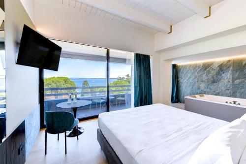 ein Hotelzimmer mit einem Bett und einem großen Fenster in der Unterkunft Hotel Oliveto in Desenzano del Garda