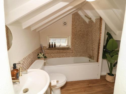 a bathroom with a tub and a toilet and a sink at Freya's Cottage in Lincoln