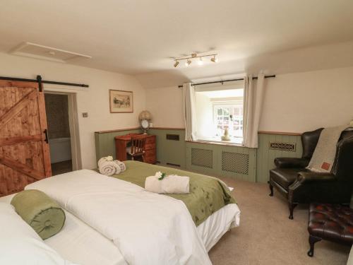 a bedroom with two beds and a chair and a window at Freya's Cottage in Lincoln
