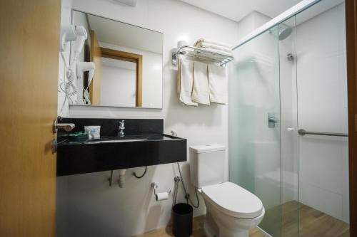 a bathroom with a toilet and a sink and a shower at Varadero Palace Hotel in Florianópolis