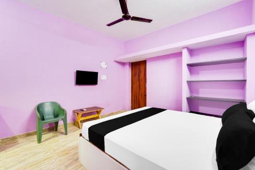 a bedroom with purple walls and a bed and a chair at Hotel O Royal Midlaans in Kālapettai