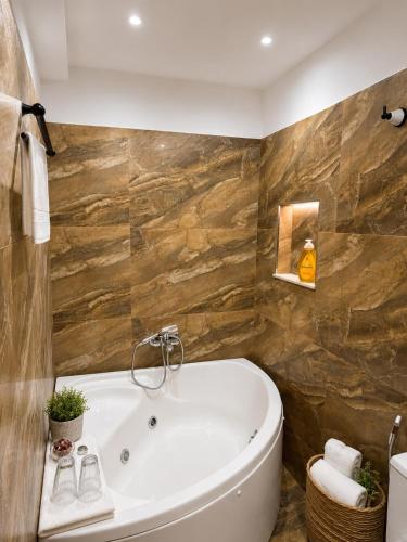 eine Badewanne in einem Badezimmer mit einer Steinwand in der Unterkunft Vila Drasa Guesthouse in Gjirokastër