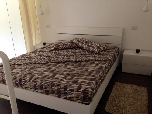 サン・ティジドーロにあるWhite Apartment Salentoのベッドルームに掛け布団付きのベッド1台が備わります。