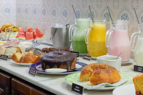 a breakfast table with different types of pastries and juice at Pousada Estalagem de Brotas in Brotas