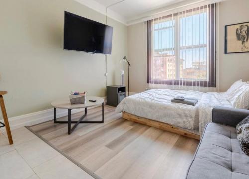 a bedroom with a bed and a couch and a tv at Apex Residence The Lake Merrit Hause in Oakland