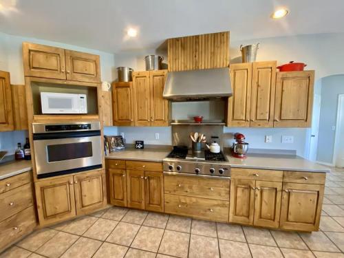 a kitchen with wooden cabinets and a stove top oven at The Gathering Place home in Montrose