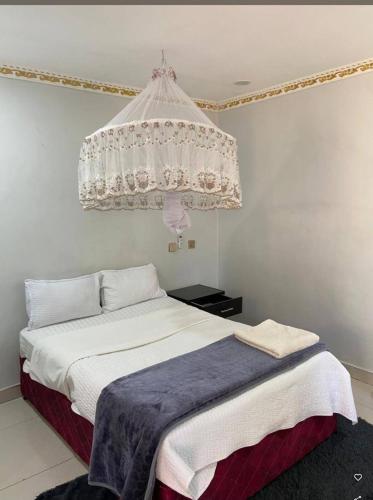 a bedroom with a bed with a chandelier above it at Mwanati Executive Lodge in Liwonde